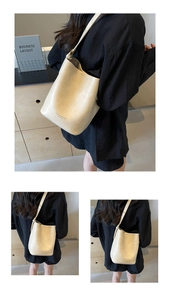 Detail of cream bucket bag with lychee texture and adjustable strap on a shoulder