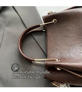 Detail view of smooth leather handle and golden metal buckle on dark brown bucket bag