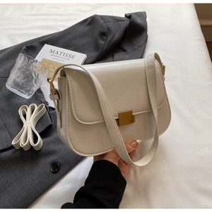 Detailed view of cream PU leather crossbody bag featuring a golden metal square lock