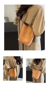 Detail view of a vintage brown leather bucket bag with brand logo and soft matte finish