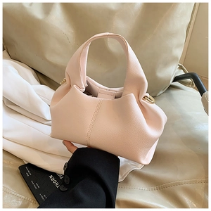Détail d'un sac à main en cuir rose clair grainé avec anneau métallique doré