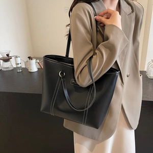 Classic black tote bag with white contrast stitching and large capacity for daily commute