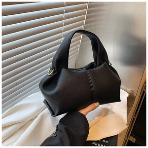 Détail du grain de litchi noir et des plis nuages sur le sac à main tendance