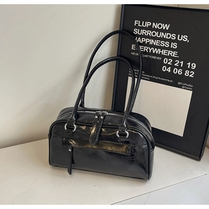 Detail of black glossy oil wax leather shoulder bag with silver zipper and long handle