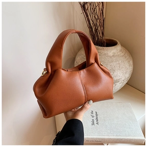 Détail d'un sac à main marron caramel en cuir grainé avec finitions dorées chic