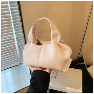 Gros plan d'un sac nuage rose clair avec texture plissée et détail d'anneau doré