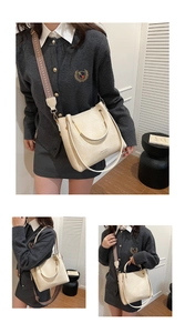 Detail view of cream bucket bag showing metal handle and wide geometric fabric strap