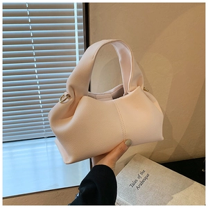 Détail d'un sac à main en cuir plissé rose pâle avec boucle élégante en métal doré