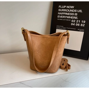 Detail of camel leather bucket bag with brand embossing on premium pebbled texture