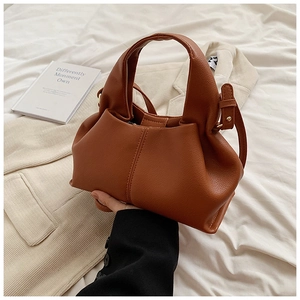 Détails du sac à main en cuir caramel avec des plis souples et des boucles dorées