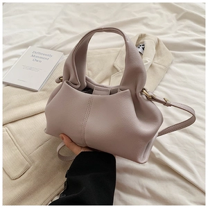 Gros plan d'un sac à main lilas plissé avec texture douce et bandoulière réglable