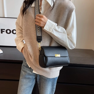 Vintage black lychee leather crossbody bag with geometric wide strap shown on model