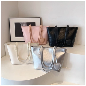 Detail view of tote bags with pleated texture and heart charms in four chic colors