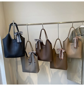 Detail of large tote bags in five colors with textured leather and checkered silk scarves