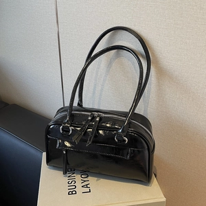 Glossy black leather shoulder bag with vintage pillow shape and long handles