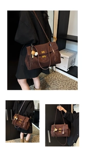 Detail view of large dark brown suede tote bag with golden twist locks and baseball charms