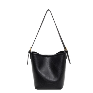 Minimalist black leather bucket bag with brass rings and adjustable shoulder strap