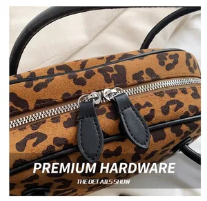 Detailansicht der Boston-Tasche mit Leopardenmuster, silbernen Reißverschlüssen und Griffen