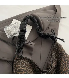 Leopard print tote bag with black ruched leather strap and decorative side bows