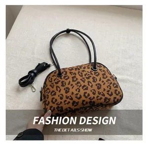 Detail einer Leopard-Print-Tasche mit schwarzen Henkeln und abnehmbarem Schultergurt