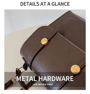 Detail of dark brown leather bag with golden hardware and neat stitching accents