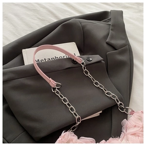 Détail de la poignée en cuir rose avec chaîne argentée et tissu en maille plissée rose