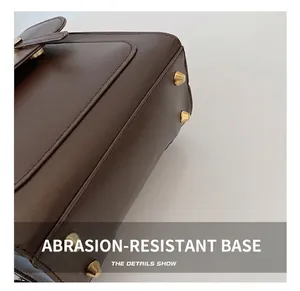 Detail of dark brown leather backpack base with four golden metal protective studs