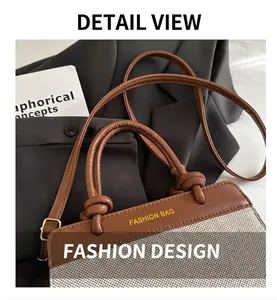 Detail of vintage brown leather and canvas contrast handbag with knotted handle