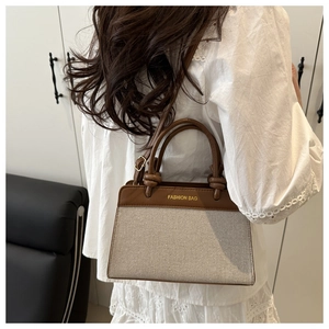 Detail of the stitching on the beige canvas and brown leather vintage crossbody bag