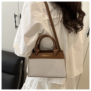 Detail of the vintage contrast leather and canvas handbag showing the long strap and handle