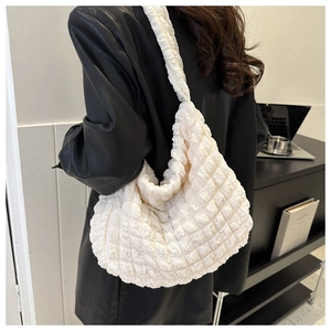 Bolso de hombro blanco crema en tejido de palomitas usado con chaqueta de cuero