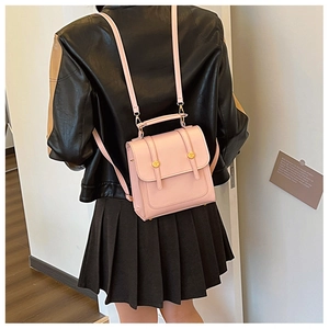 Detail of pink vintage faux leather backpack worn by model, showing size and texture