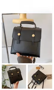 Detail shot of black faux leather backpack featuring gold buckles and retro straps