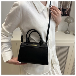 Detailed view of a vintage matte black leather crossbody bag with top handles for women