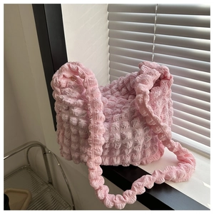 Detalle del tejido de burbujas rosa en un bolso de hombro hobo elegante para mujer