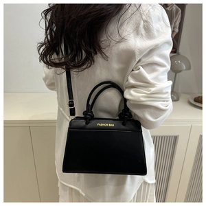 Detail of adjustable black leather strap and gold buckle on a retro women's crossbody bag