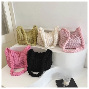Detalle de cinco colores de bolsos tipo tote con textura elástica de burbuja popcorn