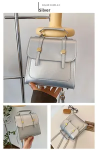Detail of silver metallic PU backpack featuring vertical buckled straps and gold hardware