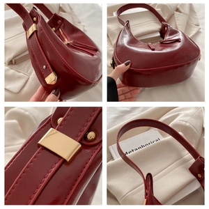 Detail view of burgundy hobo bag featuring glossy patent leather and gold hardware accents