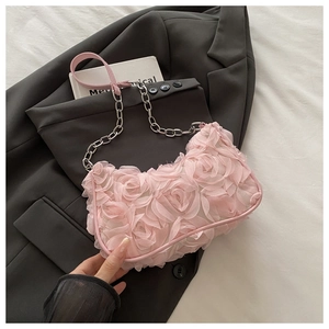 Détail du sac rose à fleurs 3D avec roses délicates et bandoulière en chaîne argentée