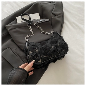 Détail de fleurs de roses noires 3D sur un sac à bandoulière vintage avec chaîne argentée
