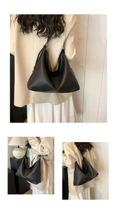 Detail of minimalist black pebbled leather tote bag with adjustable metal buckle strap