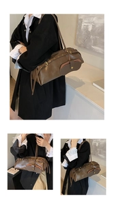 Detail of dark brown leather Boston bag with metal eyelets and mini purse attachment