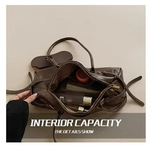 Detail showing high-capacity interior of brown leather Boston bag with zip closure