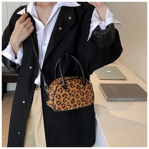Detail der Boston-Tasche mit Leopardenmuster und schwarzem Mantel für Stil und Textur