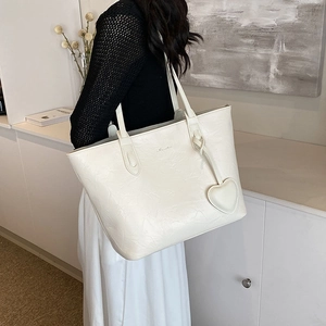 Minimalist beige crinkled tote bag with double straps and heart pendant in a chic setting