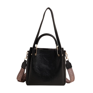 Fashionable black bucket handbag with woven wide strap and golden hardware in sleek leather