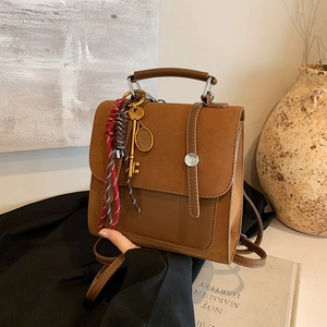 Vintage brown leather patchwork backpack with decorative charms and top handle