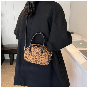 Detailansicht der Leoparden-Kissen-Tasche mit schwarzen Ledergriffen und Schultergurt