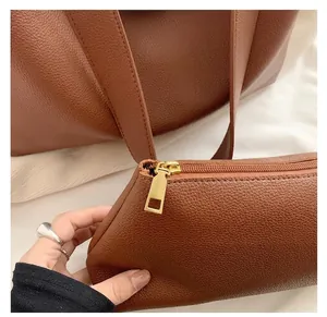 Detail of the high-quality gold zipper and pebbled leather texture on the brown tote bag